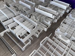 Several white plastic drawer organizers are arranged in rows on a wooden surface.