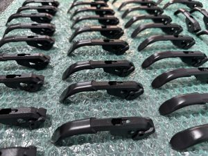 Rows of black metal levers arranged neatly on a sheet of bubble wrap.