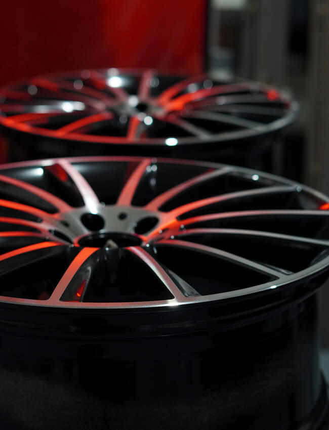 Two black multi-spoke car wheels with silver accents and a PB Powder Coating finish.